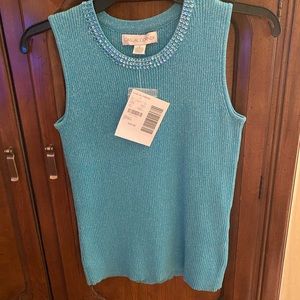 Shell petite small. Aqua with a sequin around the the top.